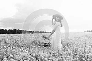 monochrome portrait of young girl in a hat standing in a huge fi