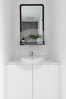 Monochrome powder room vanity black mirror and white tiling