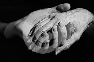 Monochrome Shot Of Young Woman Holding Older Woman's Hand photo