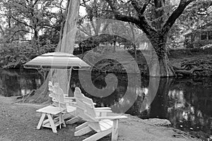 Monochrome View of Sun Umbrella and White Chairs by Blanco River