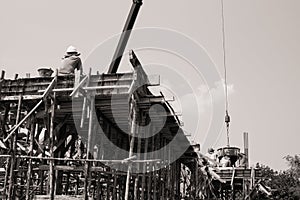 Monochrome of workers carrying the cement container to pour at s