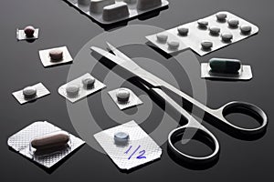 Monodose medication pills with scissors, conceptual image