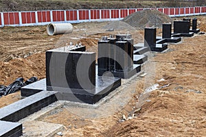 Monolithic reinforced concrete foundation waterproofed with bituminous mastic. Rostverk at the construction site. Construction pit