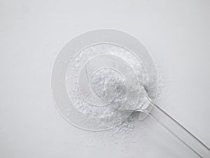 Monosodium Glutamate MSG on plastic spoon with white background.