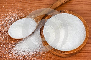 Monosodium glutamate on wooden bowl and spoon on the table background, MSG for food seasoning
