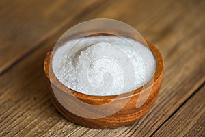 Monosodium glutamate on wooden bowl on the table background, MSG for food seasoning