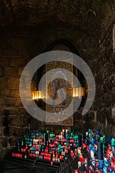 Monserrat Monastery`s votive candles and portrait of Mary and baby Jesus, Catalonia, Spain