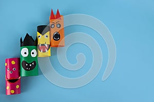 Funny monsters on light blue background, flat lay with space for text. Halloween decoration