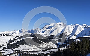 Mont Blanc in background and Saint-Gervais ski resort in foreground during winter season - View from Megeve, Haute-Savoie, Rho
