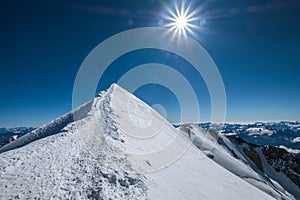 Mont Blanc Monte Bianco snowy 4808m summit wide angle view with surrounded French Alps landscape with deep blue sky and bright