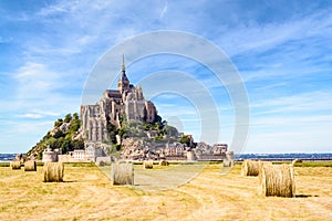 The Mont Saint-Michel tidal island in France with round bales of straw