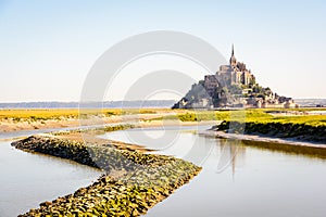 The Mont Saint-Michel tidal island in Normandy, France, and the Couesnon river by a sunny morning