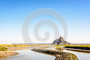 The Mont Saint-Michel tidal island in Normandy, France, and the Couesnon river by a sunny morning