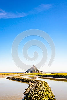 The Mont Saint-Michel tidal island in Normandy, France, and the Couesnon river by a sunny morning