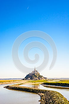 The Mont Saint-Michel tidal island in Normandy, France, and the Couesnon river by a sunny morning