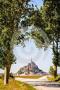 The Mont Saint-Michel tidal island in Normandy, France, seen between poplar trees