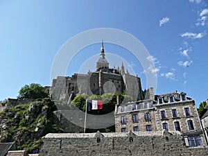 Mont Saint Michel and the waving French flag, Normandy, France