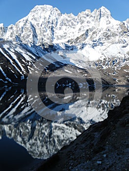 montagna innevata riflessa su lago ghiacciato photo