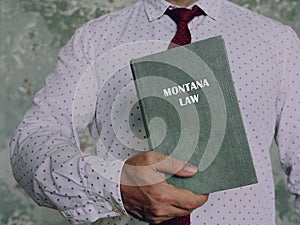 MONTANA LAW book in the hands of a lawyer. Montana residents are subject to Montana state and U.S. federal laws