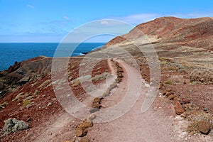 Montana Roja Red mountain path in volcanic area with red rocks and soil, ground lava field, El Medano, Tenerife photo