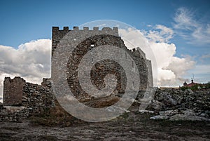 Montanchez castle ruins in Spain, lateral view with toppled walls and battlements