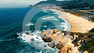 Montara State Beach in California. Aerial Flying over a beautiful beach with a rocky shore and ocean waves coming to the