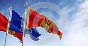 Montenegro and European Union flags waving in the wind on a clear day