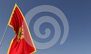 Montenegro flag on flagpole on blue background. Place for text. The flag is unfurling in wind. Europe, Podgorica. Balkans. 3D