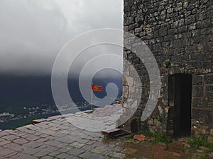 A montenegro flag flutters undefeated under heavy thunder clouds in Kotor harbour in Montenegro