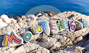 Montenegro inscription made of painted stones on rocks, sea background