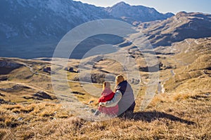 Montenegro. Mom and son tourists in the background of Durmitor National Park. Saddle Pass. Alpine meadows. Mountain