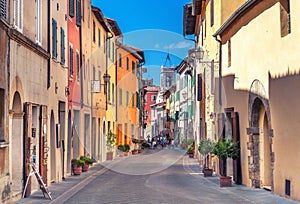 Montepulciano, Italy - August 25, 2013: Old narrow street in the center of town with colorful facades.