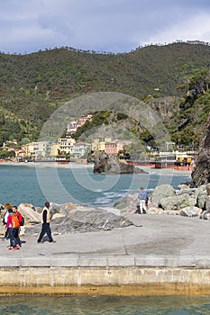 View on seaside, people on the stone pier, Monterosso, Cinque Terre, Italy