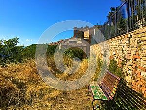 Monterubbiano town, Fermo province, Marche region, Italy. Wall, bench and secret path