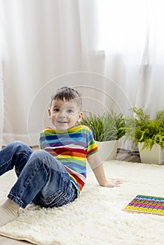 Montessori material. Boy study at a home school. Son in rainbow clothes