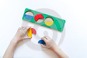 Montessori material. Children`s hands. Whole and part. Fractions. The study of mathematics