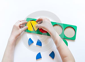 Montessori material. Children`s hands. Whole and part. Fractions. The study of mathematics