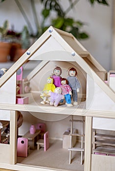 Montessori material. Large wooden doll house with a doll family inside