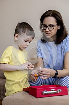 Montessori material. Mom and son play doctor. Profession game