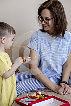 Montessori material. Mom and son play doctor. Profession game