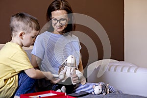 Montessori material. Mom and son play doctor. Profession game