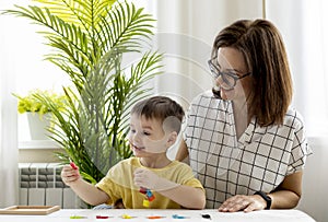 Montessori material. Woman and a boy are studying a puzzle with keys and locks