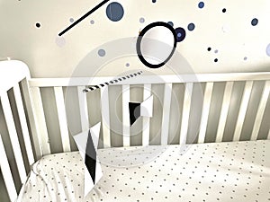 Montessori Munari Mobile carousel hanging and spinning above baby bed. Black and white geometrical shapes that improves babies