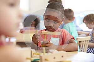 Montessori Pupil Working At Desk With Wooden Shapes