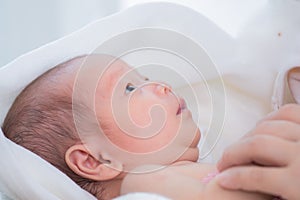 0-1 month Asian newborn baby looking to her mom with curiosity, infant open eye effect with light but still not see anything, baby
