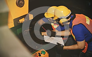 The technicians work as a team to inspect the use of hydraulic machines in the factory.