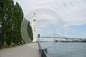 Montreal Clock Tower and Jacques Cartier Bridge at Old Port, Montreal, Canada. Background is a blue cloudy sky. Right is Saint