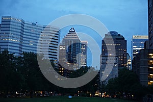 Montreal, QC, Canada - 7-15-2021: A skyline of Downtown, Sherbrooke street at the twilight blue hour. Foreground is McGill