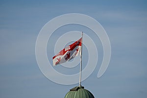 Montreal, QC, Canada - 8-4-2021: Isolated flag of McGill university flies in the air in a windy day with a background of a clear