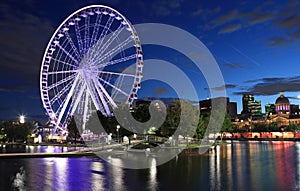 Montreal, Quebec, Canada - August 18, 2023: Montreal skyline illuminated at dusk, including the Giant Wheel attraction.